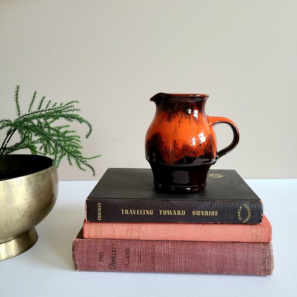 Orange/red ceramic pitcher/creamer. Miniature pottery.